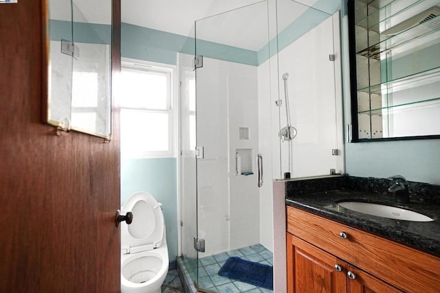 bathroom with tile patterned floors, toilet, vanity, and walk in shower