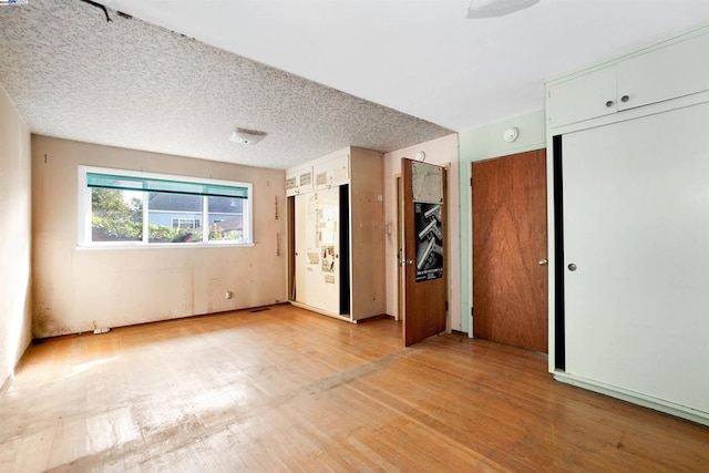 interior space with a textured ceiling and light wood-type flooring