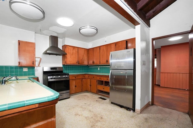 kitchen with decorative backsplash, sink, stainless steel appliances, and wall chimney range hood