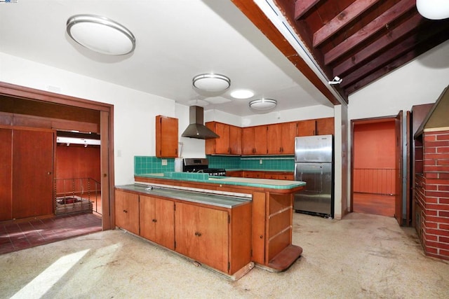 kitchen featuring tasteful backsplash, wall chimney exhaust hood, stainless steel appliances, and light colored carpet