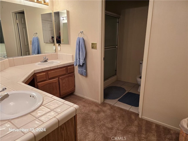 bathroom featuring tile patterned floors, walk in shower, vanity, and toilet