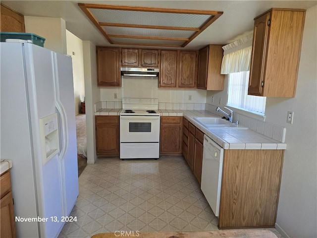 kitchen featuring tile countertops, sink, and white appliances