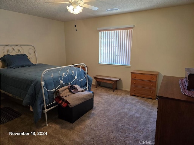 bedroom featuring carpet, ceiling fan, and a textured ceiling