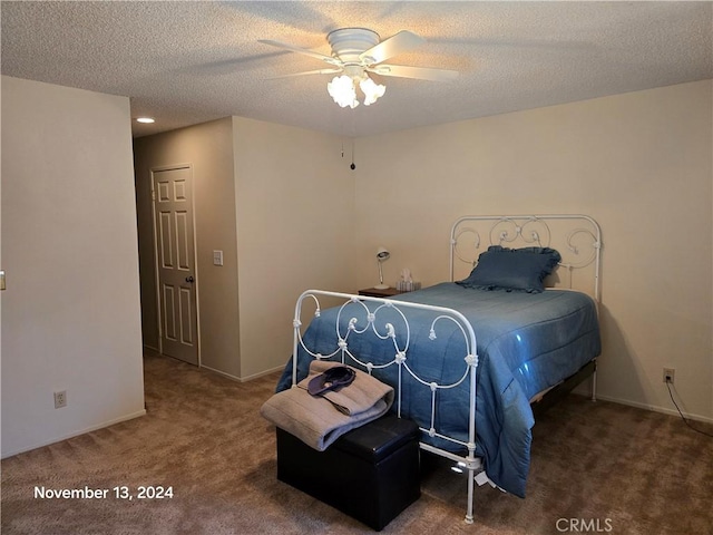 carpeted bedroom with ceiling fan and a textured ceiling