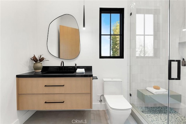 bathroom featuring an enclosed shower, vanity, and toilet