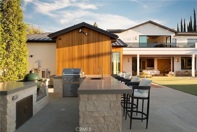 view of patio / terrace with exterior kitchen, a grill, a balcony, and a wet bar