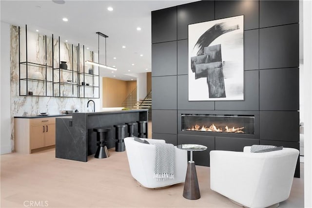 interior space with pendant lighting, sink, and backsplash