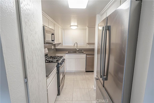 kitchen featuring light tile patterned flooring, stainless steel appliances, white cabinetry, and sink