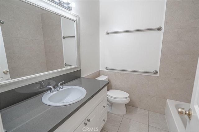 bathroom with vanity, tile patterned floors, toilet, tile walls, and a tub