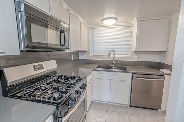 kitchen featuring sink, white cabinets, light tile patterned flooring, and appliances with stainless steel finishes