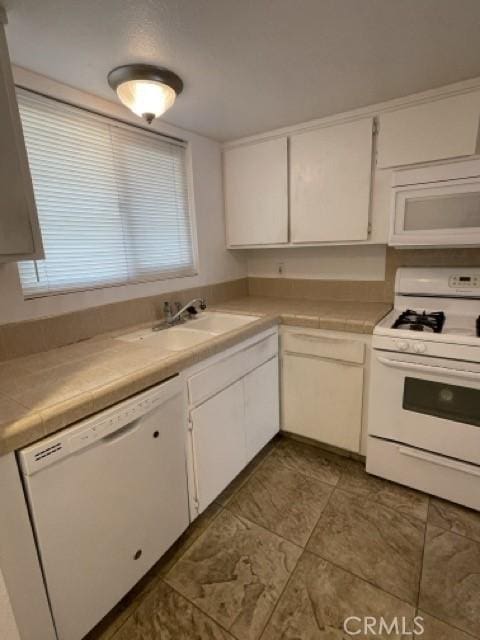 kitchen featuring white cabinetry, sink, white appliances, and tile counters