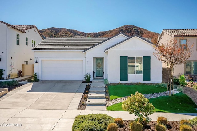 view of front of house featuring a mountain view, a garage, and a front yard