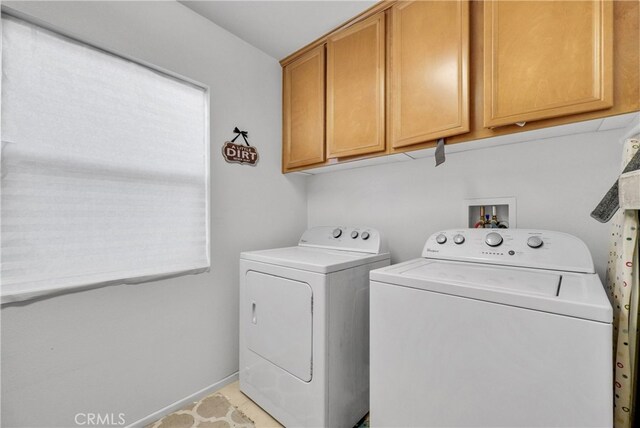 laundry area with cabinets, light tile patterned floors, and washer and dryer