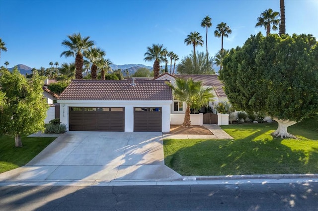 view of front of house with a front lawn, a garage, and a mountain view