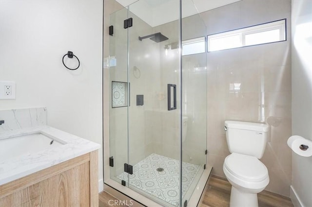 bathroom featuring hardwood / wood-style floors, vanity, toilet, and walk in shower