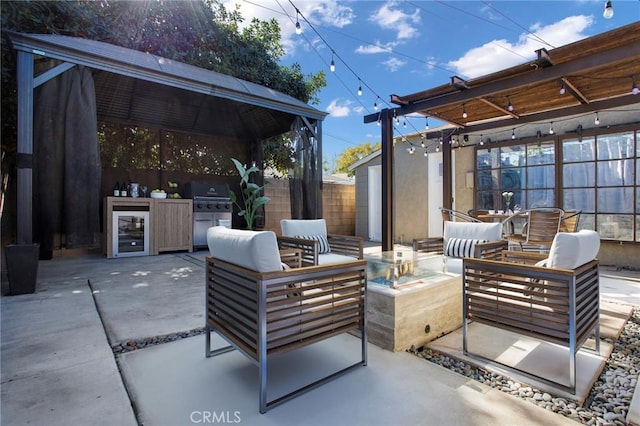 view of patio with outdoor lounge area, an outdoor kitchen, area for grilling, and beverage cooler