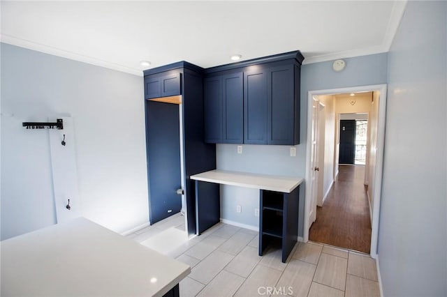 kitchen with light hardwood / wood-style floors, blue cabinets, and ornamental molding