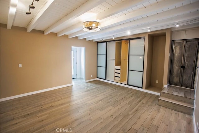 interior space with beamed ceiling, wood ceiling, and light hardwood / wood-style flooring