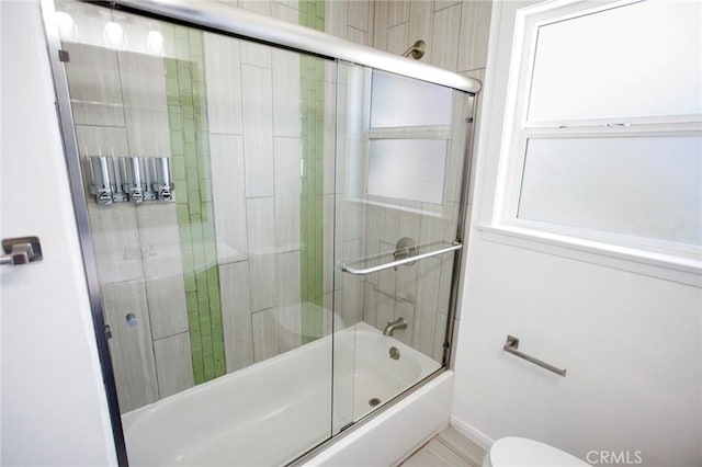 bathroom featuring shower / bath combination with glass door and toilet