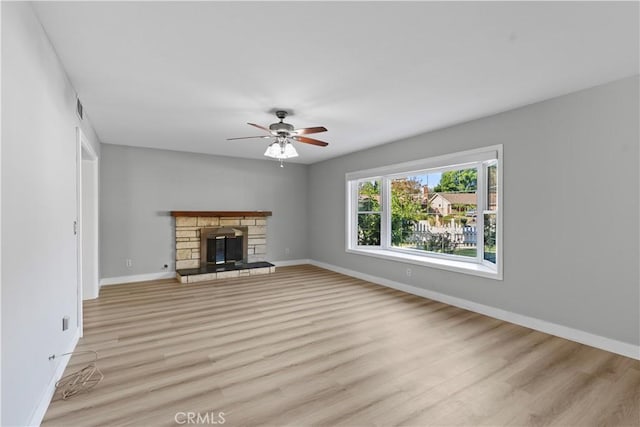 unfurnished living room featuring ceiling fan, a fireplace, and light hardwood / wood-style floors