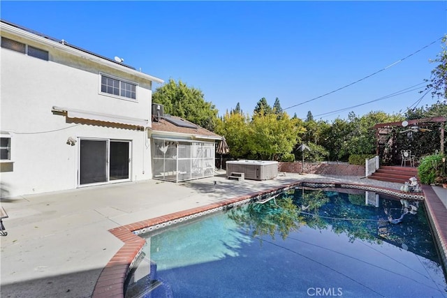 view of swimming pool with central air condition unit, a patio, and a hot tub