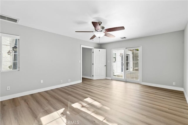 empty room with ceiling fan, a healthy amount of sunlight, and light hardwood / wood-style floors