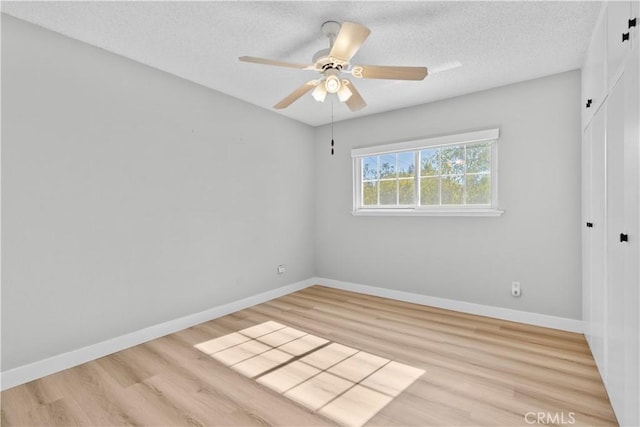 spare room featuring a textured ceiling, light hardwood / wood-style floors, and ceiling fan