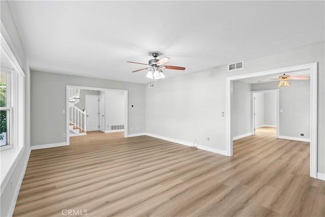 unfurnished living room featuring ceiling fan and light wood-type flooring