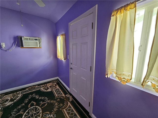 doorway to outside with an AC wall unit, ceiling fan, and lofted ceiling