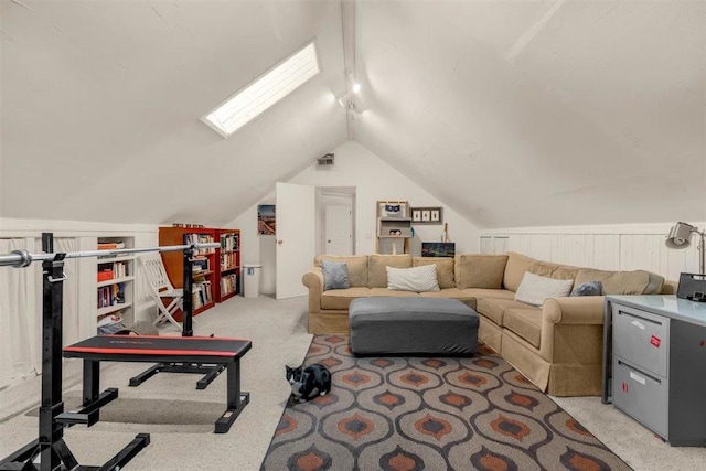 carpeted living room with vaulted ceiling with skylight