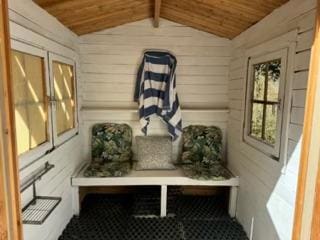 mudroom with wood ceiling, lofted ceiling, and wood walls