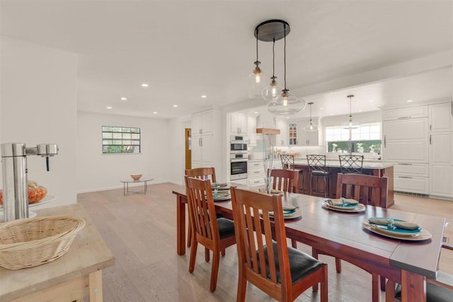 dining space with a healthy amount of sunlight and light hardwood / wood-style floors