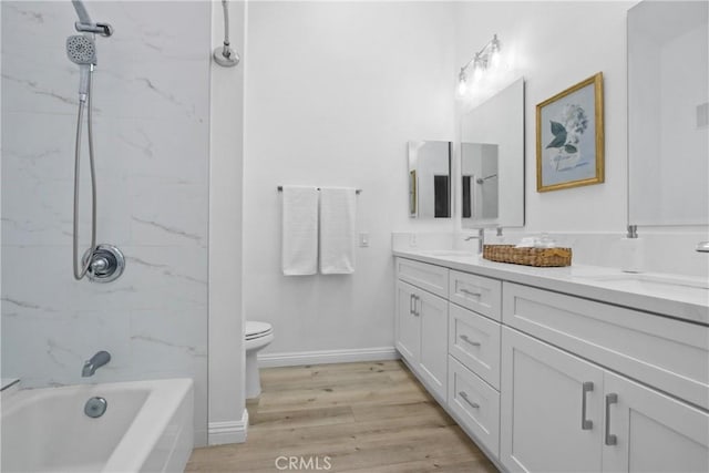 full bathroom featuring wood-type flooring, vanity, toilet, and tiled shower / bath combo