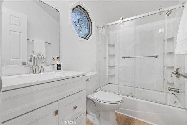 full bathroom featuring toilet, enclosed tub / shower combo, wood-type flooring, and vanity