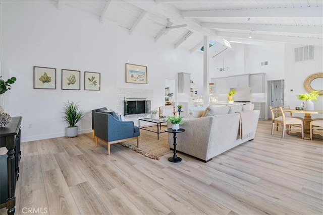 living room featuring high vaulted ceiling, light hardwood / wood-style flooring, a brick fireplace, and beamed ceiling