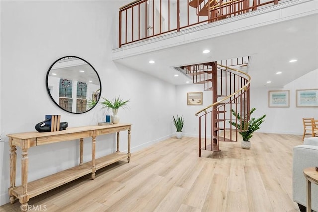 foyer entrance featuring a towering ceiling and wood-type flooring