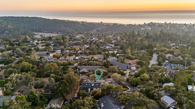 aerial view at dusk featuring a water view