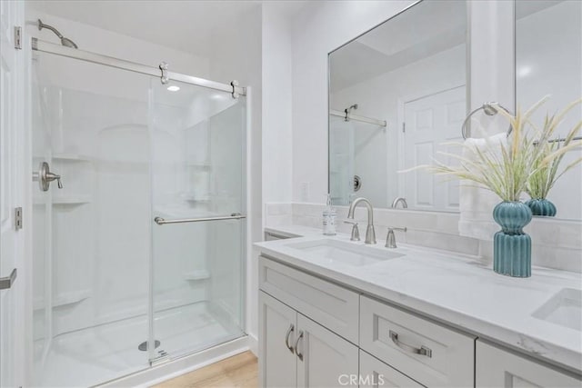 bathroom featuring an enclosed shower, vanity, and wood-type flooring