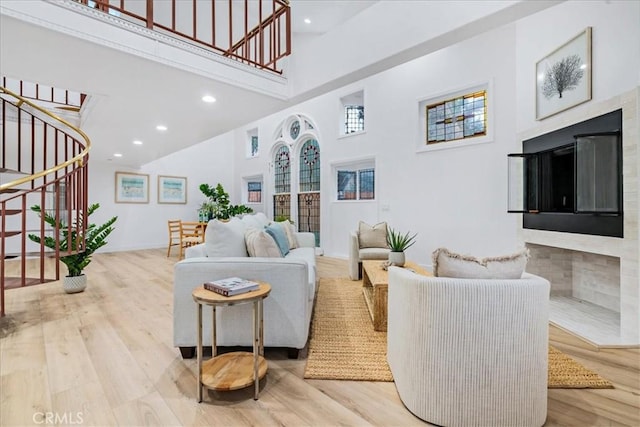 living room featuring a towering ceiling and light hardwood / wood-style flooring