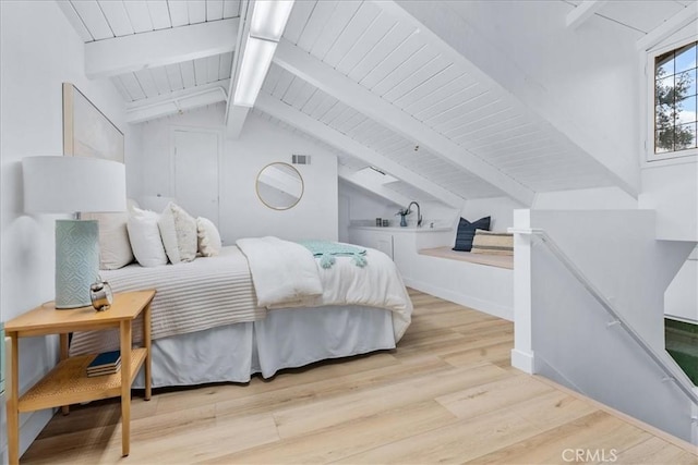 bedroom with light hardwood / wood-style floors and lofted ceiling with beams