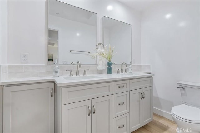 bathroom featuring hardwood / wood-style flooring, toilet, and vanity