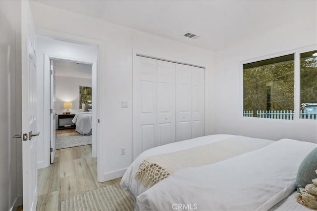 bedroom with light wood-type flooring and a closet