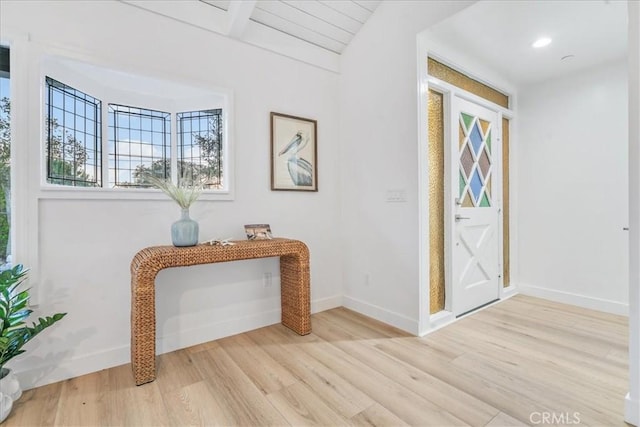 foyer with light hardwood / wood-style flooring and beamed ceiling