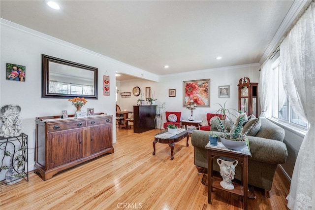 living room with light wood-type flooring and ornamental molding