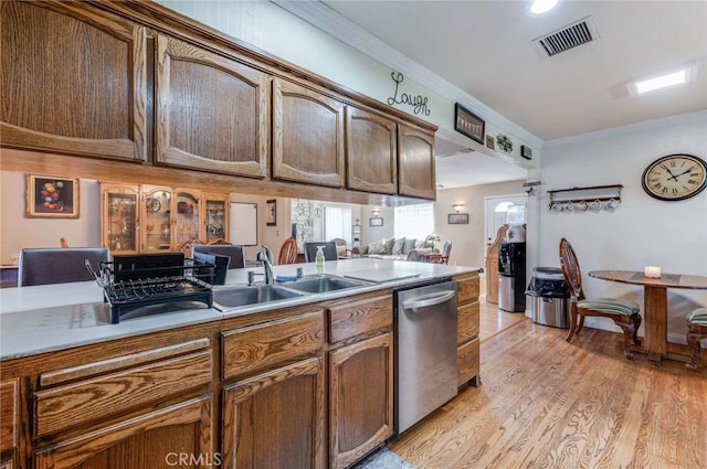 kitchen featuring ornamental molding, light hardwood / wood-style floors, dishwasher, and sink