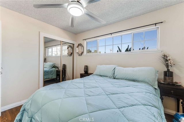 bedroom featuring ceiling fan, a closet, dark wood-type flooring, and a textured ceiling