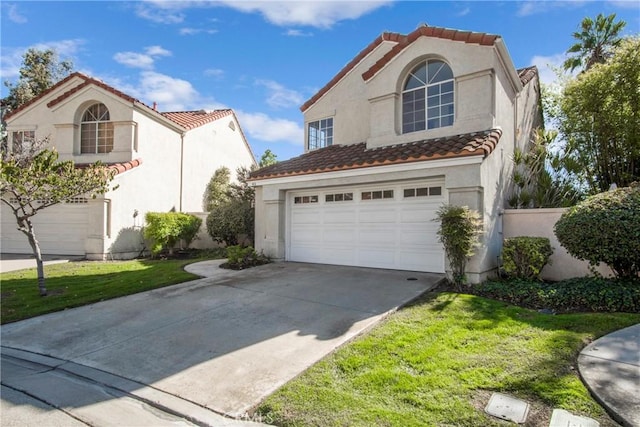 mediterranean / spanish home with a garage and a front lawn