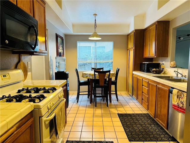 kitchen featuring dishwasher, tile counters, gas range gas stove, and light tile patterned flooring