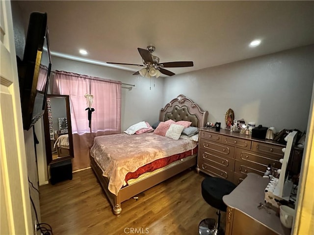 bedroom with dark hardwood / wood-style flooring and ceiling fan