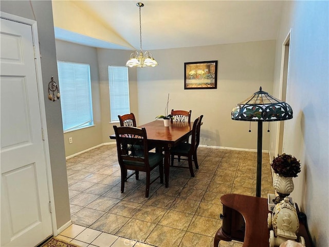 dining room featuring tile patterned flooring, vaulted ceiling, and an inviting chandelier